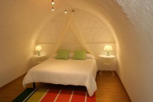 ein Bett mit zwei grünen Kissen in einem Zimmer in der Unterkunft Casa amb vista a les muntanyes - Cal Valeri in Montsonis