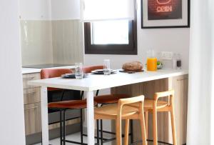 a small kitchen with a white table and chairs at 1BR Serviced Apt with Pool & Premium Amenities in Oroklini