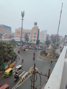 a busy city street with cars and taxis in the rain at Agrasen Homestay in Prayagraj