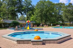 a pool with a playground with people in a park at Tiny House Mayu - Veluwe Airco 4 persons in Arnhem