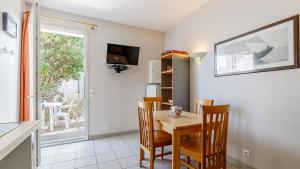 a dining room with a table and chairs and a television at L Ocean N11 2P4 in La Tranche-sur-Mer