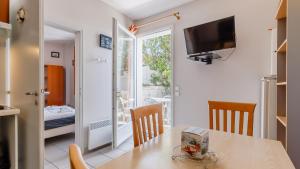 a kitchen and dining room with a table and a television at L Ocean N11 2P4 in La Tranche-sur-Mer