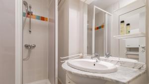 a white bathroom with a sink and a shower at L Ocean N11 2P4 in La Tranche-sur-Mer +5 photos