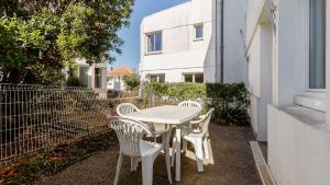 a white table and chairs on the side of a building at L Ocean N11 2P4 in La Tranche-sur-Mer