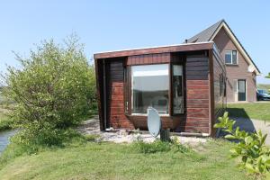 a tiny house sitting on top of a yard at Wendy in Julianadorp