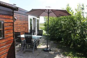 a table and chairs under an umbrella on a patio at Wendy in Julianadorp