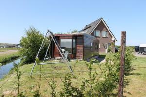 a tiny house on a hill with a swing at Wendy in Julianadorp