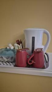 two tea pots and a pitcher on a shelf at Coolalingo B&B in Drumgoff Bridge