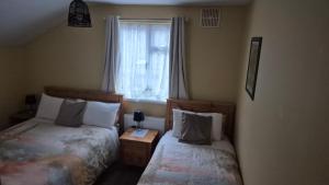 a bedroom with two beds and a window at Coolalingo B&B in Drumgoff Bridge
