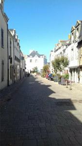 a cobblestone street in a town with white buildings at Les Salorges in Le Croisic