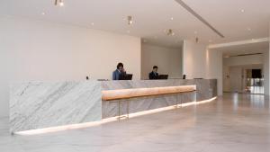 two people sitting at a reception desk in a lobby at Orient Luxury Hotel Kenting in Hengchun South Gate