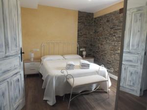 a bedroom with a bed and two chairs in a room at Apartamentos Puerta del Castro in Coaña