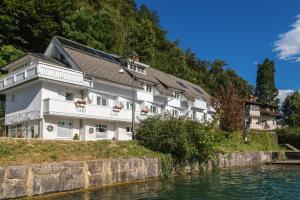 a building on a hill next to a river at Čarman House in Bled