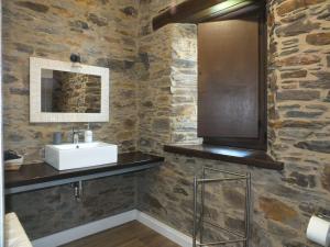 a bathroom with a sink and a stone wall at Apartamentos Puerta del Castro in Coaña +104 photos