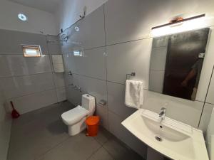 a bathroom with a sink and a toilet and a mirror at Tranquil Waves Marari in Mararikulam