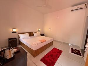 a bedroom with a bed and a red rug at Tranquil Waves Marari in Mararikulam +31 photos