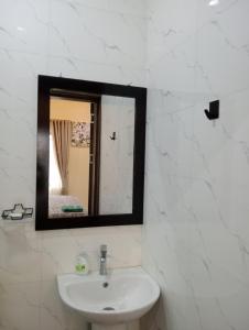 a bathroom with a sink and a mirror at Pinefield Courts Apartment in Akure
