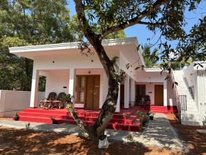 a house with red benches in front of it at Tranquil Waves Marari in Mararikulam