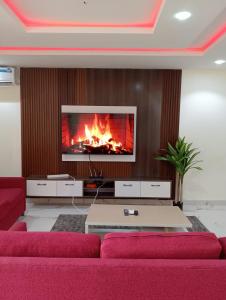 a living room with a couch and a fire at Pinefield Courts Apartment in Akure