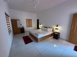 a bedroom with a bed in a white room at Tranquil Waves Marari in Mararikulam