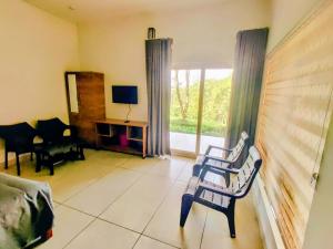 a living room with two chairs and a television at The Vagabond Stays in Vagamon