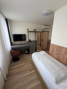 a bedroom with a bed and a desk with a computer at Turm Inn 24H Self Check In By H&H Hotels in Linz