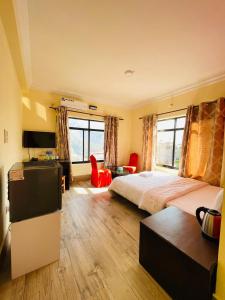 a hotel room with a bed and a desk and chairs at Gateway Himalaya Resort in Ghanpokhara +48 photos