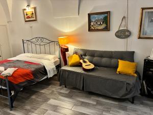 a bedroom with a bed and a guitar on a couch at La piccola casa di Tania in Terlizzi