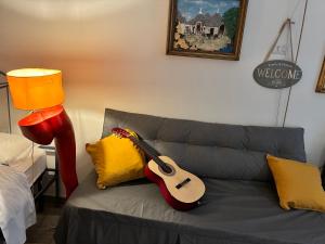 a guitar sitting on a couch in a living room at La piccola casa di Tania in Terlizzi