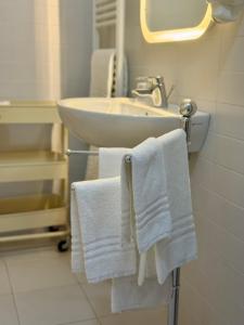 a bathroom with white towels hanging on a sink at Agriturismo Masseria Cannella in Lesina +151 photos