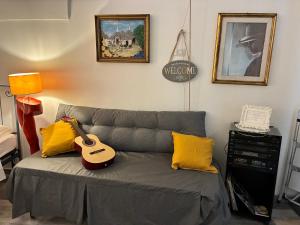 a living room with a couch with a guitar on it at La piccola casa di Tania in Terlizzi