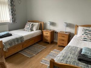 a bedroom with two beds and two night stands at Awel Deg in Pembrokeshire