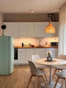 a kitchen with white cabinets and a table and chairs at Chianti's Secret Nest - Cozy home with sunset view in Impruneta