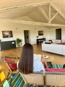 a woman sitting in a chair reading a book in a living room at Agriturismo Masseria Cannella in Lesina