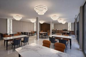 a dining room with tables and chairs and lights at Huaxia Hotel Bishkek in Bishkek