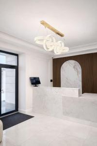 a lobby with a marble counter and a chandelier at Huaxia Hotel Bishkek in Bishkek