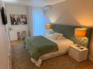 a bedroom with a large bed with two lamps on it at Green Gold Passion in Santo Estêvão +28 photos