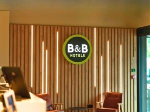 a room with chairs and a sign on the wall at B&B HOTEL Warrington in Warrington