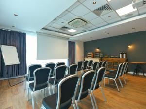 a conference room with chairs and a white screen at B&B HOTEL Warrington in Warrington