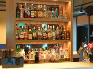 a cabinet filled with lots of bottles of alcohol at B&B HOTEL Warrington in Warrington +21 photos