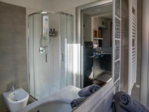 a bathroom with a shower and a sink and a tub at BASTIA RF Suite up to 4 guests - in the heart of Scalo Romana, Olimpico, Prada, Bocconi and easy access Forum Assago, IEO, IED, Duomo, San Siro in Milan +8 photos