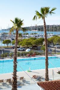 a view of a pool with palm trees and a marina at Floating House Marina in Portorož
