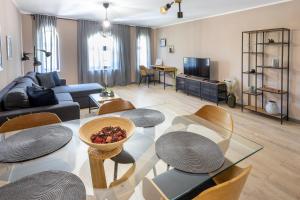 a living room with a couch and a table and chairs at MiTRa Luxury Apartments in Shumen