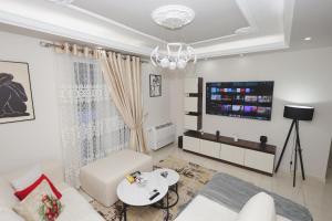 a living room with a white couch and a tv at Greis Home in Maliq