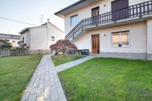 a house with a walkway in front of a yard at Dante210 in Cassina Rizzardi