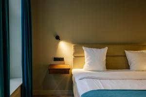 a bedroom with a bed with white sheets and pillows at Hotel 1635 in Haarlem