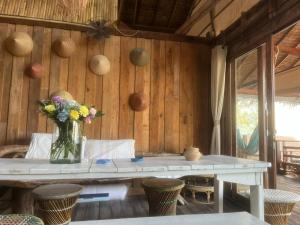 a table with a vase of flowers on it at Lipe BeachHouse in Ko Lipe +13 photos