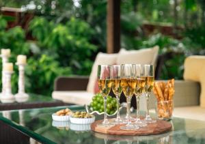 a group of wine glasses on a table with appetizers at LohonoStays Villa Lani in Alībāg