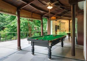 a pool table on a screened in porch with a ceiling at LohonoStays Villa Lani in Alībāg