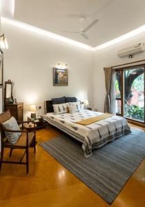 a large bedroom with a large bed and a chair at LohonoStays Villa Lani in Alībāg +27 photos